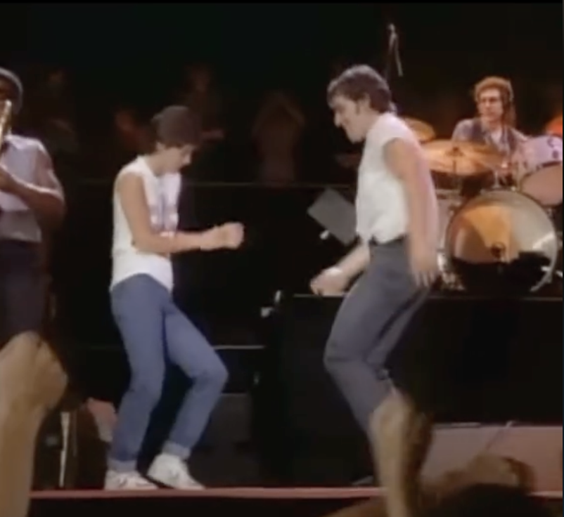 Courtney Cox dancing on stage with Bruce Springsteen